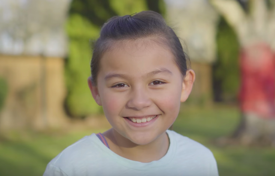Smiling girl screen capture for video highlighting Chili’s commitment to charitable giving